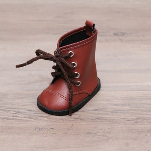 May include: A pair of brown leather lace-up boots with black laces. The boots have a rounded toe and a low heel.
