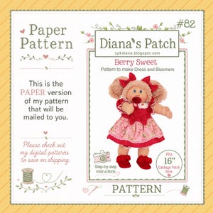 Könnte beinhalten: Ein Papierschnittmuster für ein Puppenkleid und eine Pumphose mit dem Titel Berry Sweet von Diana's Patch #82. Das Muster zeigt eine Puppe mit Wollhaaren, einem rot-rosa erdbeerbedruckten Kleid und roten Schuhen für 40 cm große Puppen.