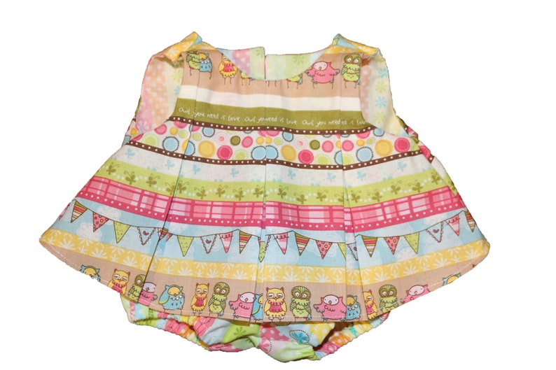 Pode incluir: Um conjunto de beb&eacute; colorido com um top e cuecas a condizer. O conjunto tem uma saia plissada e &eacute; decorado com riscas, bolinhas e ilustra&ccedil;&otilde;es de corujas. O texto "Owl you need is love" est&aacute; impresso no tecido.
