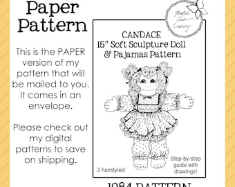 May include: A black and white paper pattern for a 15-inch soft sculpture doll and pajamas, labeled "Candace." The pattern includes step-by-step instructions and three hairstyles. The text reads "Paper Pattern" and "1984 Pattern."