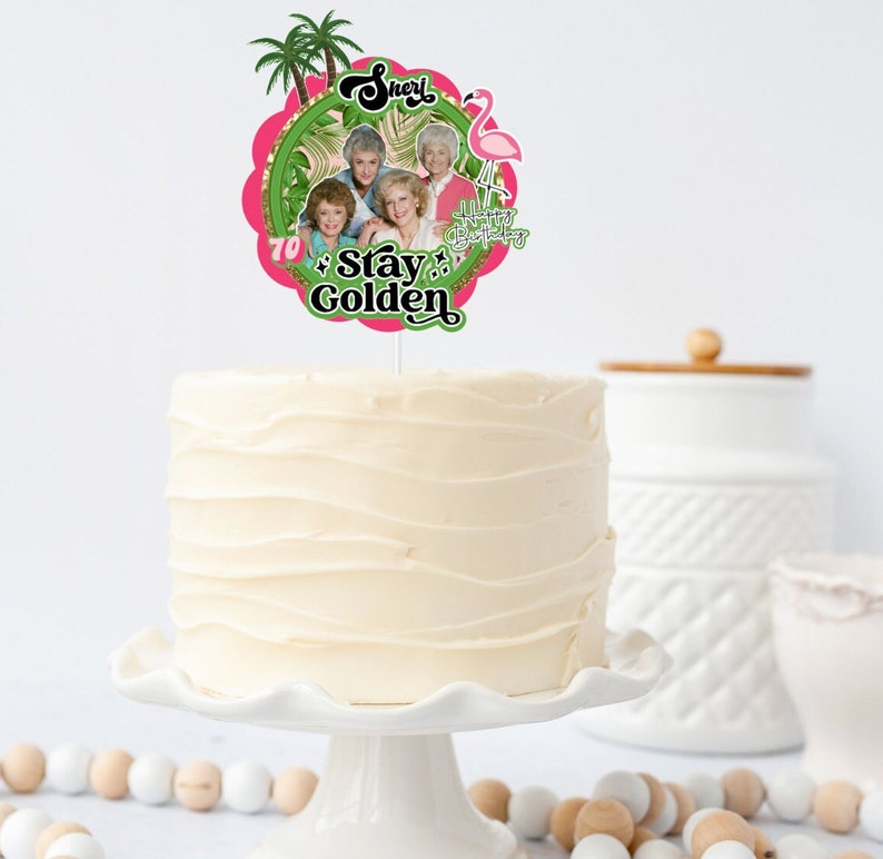 May include: A pink and green cake topper with a picture of the Golden Girls and the text "Sheri 70 Stay Golden".
