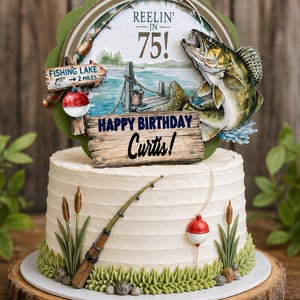 May include: A round cake topper featuring a fishing theme with a jumping fish, a fishing rod, and a sign that reads REELIN' IN 75! and FISHING LAKE 2 MILES. Below, a wooden sign reads HAPPY BIRTHDAY Curtis! on a white frosted cake with grass.