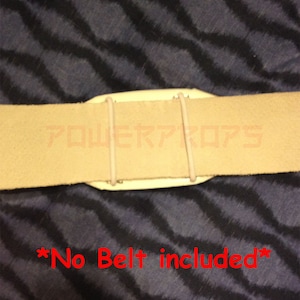 May include: A close-up of a beige belt with a white plastic piece and two beige elastic bands. The text "POWER PROPS" is visible on the belt. The text "*No Belt included*" is written in red.