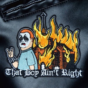 May include: Embroidered patch featuring a cartoon character in a black metal band outfit, with a house engulfed in flames behind them. The text "That Boy Ain't Right" is below the image.