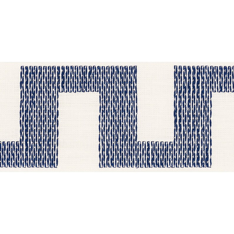 May include: A white fabric with a navy blue geometric pattern. The pattern is made up of repeating squares and rectangles.