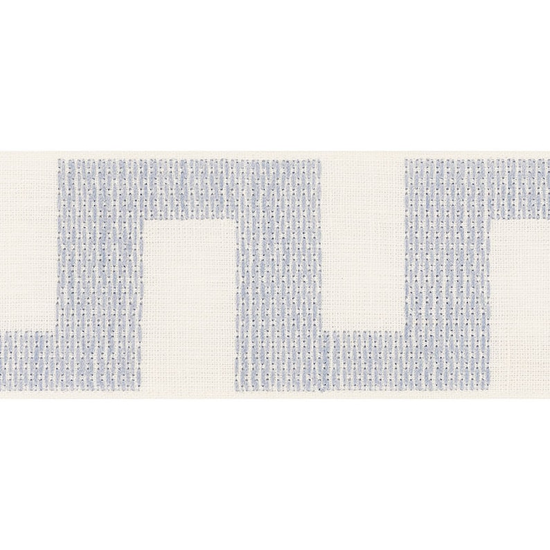 May include: A white fabric trim with a blue geometric pattern. The pattern is a series of interlocking rectangles.