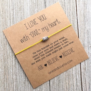 May include: A yellow string bracelet with an owl charm and a card that reads "I LOVE YOU with "OWL" my heart. Tie this bracelet on your wrist, close your eyes and make a wish, when this bracelet breaks in two, the wish you made might just come true. ASK BELIEVE RECEIVE arieandco.etsy.com"
