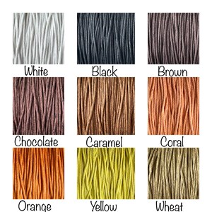 Op de afbeelding: Negen verschillende kleuren katoenen koord, waaronder wit, zwart, bruin, chocolade, karamel, koraal, oranje, geel en tarwe.