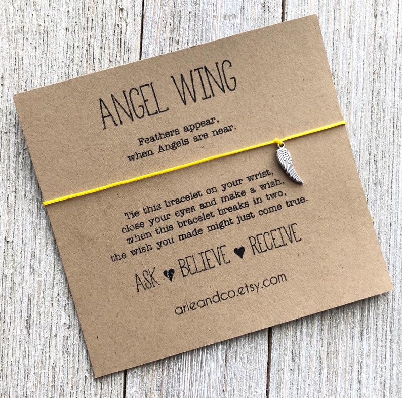 May include: A yellow string bracelet with a silver angel wing charm. The card attached to the bracelet reads "ANGEL WING Feathers appear, when Angels are near. Tie this bracelet on your wrist, close your eyes and make a wish, when this bracelet breaks in two, the wish you made might just come true. ASK BELIEVE RECEIVE arieandco.etsy.com"