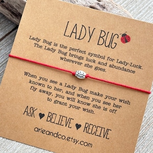 May include: Red string bracelet with a silver ladybug charm. The card attached to the bracelet reads "Lady Bug is the perfect symbol for Lady-Luck. The Lady Bug brings luck and abundance wherever she goes. When you see a Lady Bug make your wish known to her, and when you see her fly away, you will know she is off to grant your wish. ASK BELIEVE RECEIVE arieandco.etsy.com"