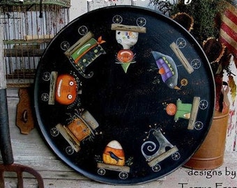 May include: A black painted wooden tray with a circle of whimsical harvest pull toys painted on it. The toys include a pumpkin, a crow, a cat, a candy corn, and a gingerbread man. The tray is decorated with the text "Harvest Pull Toys" and "designs by, Terrye French".