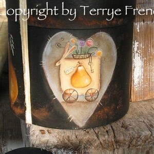 May include: A black painted wooden box with a heart-shaped design and a painted image of a rabbit pulling a cart with a pear. The box is decorated with a white ribbon and dried flowers. The text "hearts pears" is written in black on a white background.