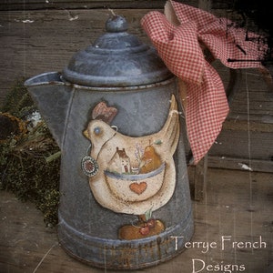 Peut inclure: Une cafetière vintage en métal bleu avec un motif peint d'une poule blanche tenant un panier de fruits et une petite maison. La cafetière est ornée d'un tissu à carreaux rouge et blanc noué autour de la poignée. Le texte "Terrye French Designs" est écrit au bas de la cafetière.