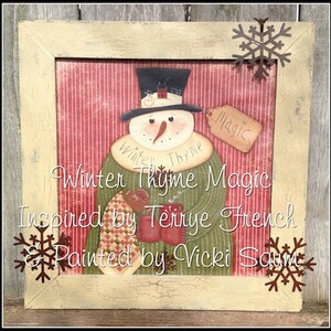 May include: A framed painting of a snowman wearing a green coat and a black top hat. The snowman is holding a red mug and a red and green patchwork quilt. The painting is titled "Winter Thyme Magic" and is inspired by Terrye French and painted by Vicki Saum.