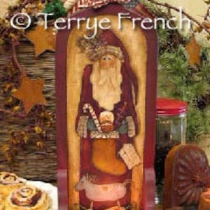 Puede incluir: Un portavelas de madera con una imagen pintada de Papá Noel sosteniendo un bastón de caramelo y una taza. El portavelas tiene una base roja y una parte superior marrón con un pequeño ciervo y una vela en el centro.