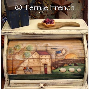 May include: A white painted bread box with a hand-painted scene of a farmhouse with a red door, a pumpkin, a wagon, and sheep in a field. The bread box has a hinged lid and a small drawer. The text "thepaintedpearbasket" is visible on the bottom of the image.