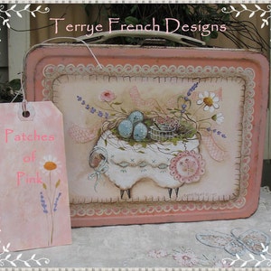 May include: A pink metal tray with a painted design of a white sheep with a basket of blue eggs and flowers. The tray has a scalloped edge and a white tag that says "Patches of Pink".
