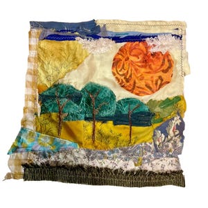 May include: Textile art piece depicting a landscape scene. The artwork features a vibrant orange sun with a detailed pattern, green trees, and a yellow field. The sky is a mix of blue and white, with a textured, layered design.