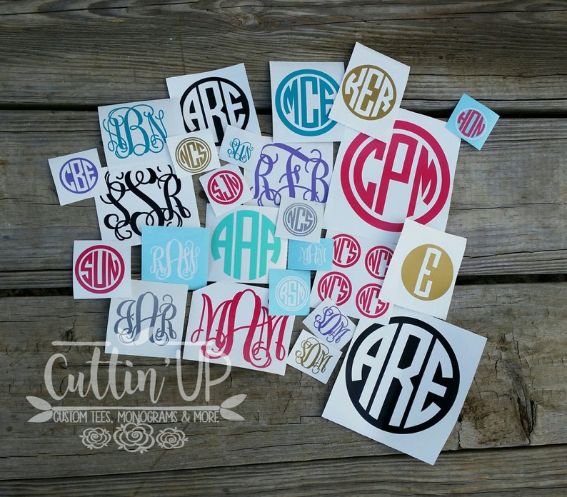 Puede incluir: Una colecci&oacute;n de calcoman&iacute;as de monogramas en varios colores y estilos, incluyendo negro, turquesa, rosa y dorado. Las calcoman&iacute;as presentan iniciales en dise&ntilde;os circulares y cuadrados. El texto "Cuttin' Up" es visible en la parte inferior, junto con "CUSTOM TEES, MONOGRAMS & MORE".