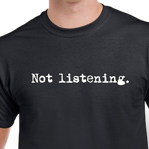 May include: A black t-shirt with white text that reads "Not listening."