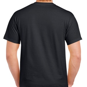 May include: A black crew neck t-shirt. The short-sleeved shirt is made of a soft material. The back of the shirt is visible, with the person's arms at their sides. The person is wearing dark-colored pants.
