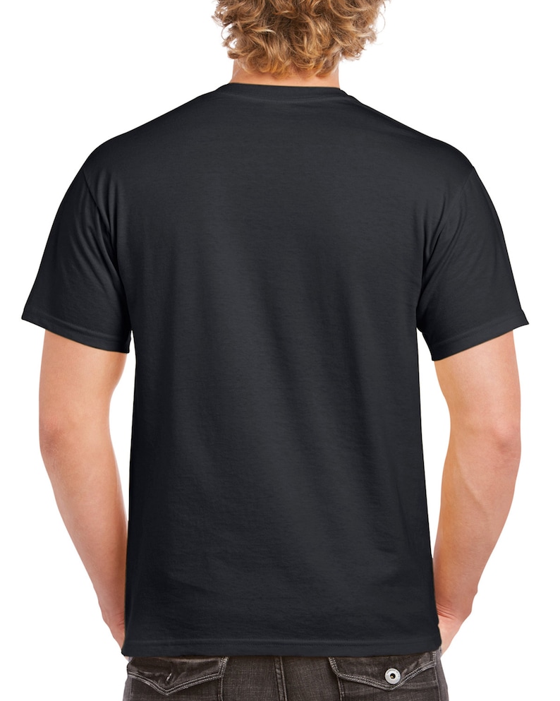 May include: A black crew neck t-shirt. The short-sleeved shirt is made of a soft material. The back of the shirt is visible, with the person's arms at their sides. The person is wearing dark-colored pants.