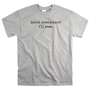 May include: A heather grey t-shirt with the text "Social interaction? I'll pass." printed in black.