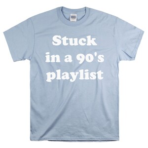 May include: Light blue t-shirt with white text that reads "Stuck in a 90's playlist".