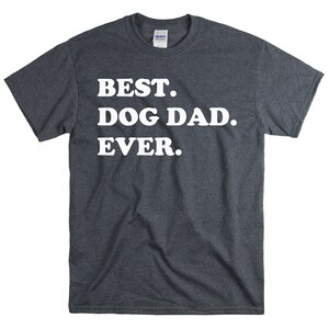 Pode incluir: Uma camiseta cinza escura mesclada com o texto "BEST. DOG DAD. EVER." impresso em branco.