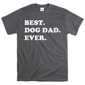 Pode incluir: Uma camiseta cinza escura com o texto "BEST. DOG DAD. EVER." impresso em branco.