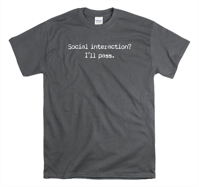 May include: A dark grey t-shirt with the text "Social interaction? I'll pass." printed in white.