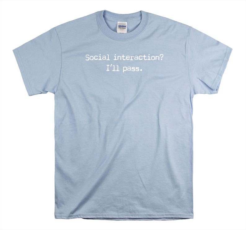 May include: Light blue t-shirt with the text "Social interaction? I'll pass." printed in white.
