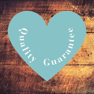 May include: A light blue heart shape with the words "Quality Guarantee" in white, set against a rustic, wooden background. The text is curved to follow the heart's shape, creating a visually appealing design.