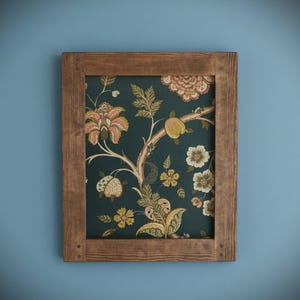 May include: A framed floral print with a dark teal background and a brown wooden frame. The print features a botanical design with peach, yellow, and white flowers and fruit. The frame is made of natural wood.