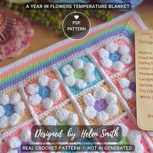 Puede incluir: Una manta de ganchillo hecha a mano con un diseño floral, con flores blancas, azules y moradas sobre un fondo pastel. La manta está etiquetada como "A Year in Flowers Temperature Blanket" y "Designed by Helen Smith". También se ven una vela y una etiqueta de madera con detalles de color.