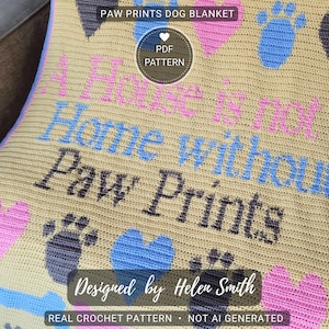 May include: A beige crochet dog blanket with the words "A Home is not a Home without Paw Prints." The blanket has paw prints, hearts, and a bone design in blue, pink, and grey. The text "Designed by Helen Smith" is also visible.