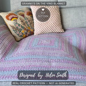 May include: A crocheted blanket in shades of lavender, gray, and pink, with a square central design. The blanket is draped over a gray sofa, with two decorative pillows. Text on the image reads "GRANNY'S ON THE VINO BLANKET" and "Designed by Helen Smith."