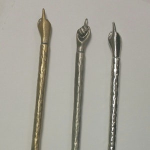 Może przedstawiać: Trzy srebrne i złote wskaźniki metalowe z uniesionym wzorem dłoni na górze. Wskaźniki są fakturowane i mają łańcuch przymocowany do dołu.