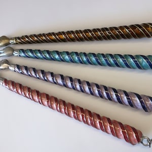 May include: Four silver and enamel yad, or Jewish pointer, with a chain. The yads are twisted and have different coloured enamel: brown, teal, purple, and red.