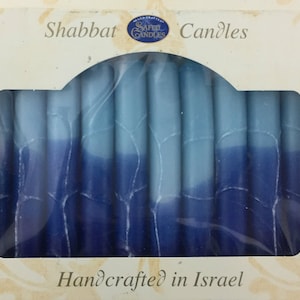 May include: A box of blue and white Shabbat candles, handcrafted in Israel. The candles are arranged in a row and are ready to be lit.