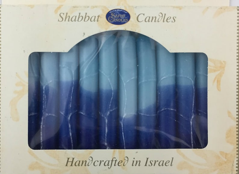 May include: A box of blue and white Shabbat candles, handcrafted in Israel. The candles are arranged in a row and are ready to be lit.