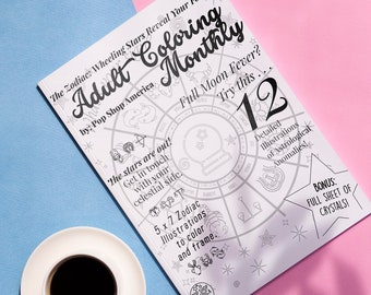 May include: A black and white coloring book with a zodiac wheel design. The cover features the title "Adult Coloring Monthly" and the text "The Zodiac: Wheeling Stars Reveal Your Fortune".