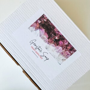 May include: White cardboard box with a label that says "Gemstone Soap Craft Supply Kit" and a picture of purple and pink gemstones.