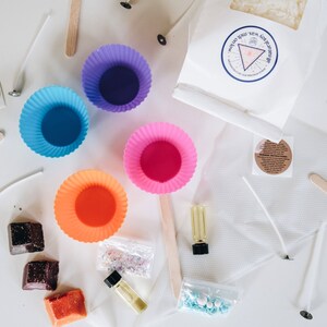 May include: A candle making kit with colorful silicone molds, wax flakes, wicks, essential oil, and sprinkles. The kit also includes instructions and a wooden stirrer.