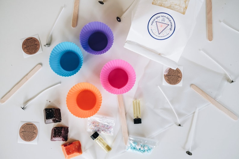 May include: A candle making kit with colorful silicone molds, wax flakes, wicks, essential oil, and sprinkles. The kit also includes instructions and a wooden stirrer.