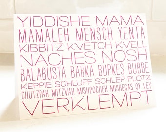 May include: A white card with pink text featuring a list of Yiddish words and phrases, including "Yiddish Mama", "Mamaleh", "Kvetch", "Naches", "Bubbe", "Schluff", "Chutzpah", "Mitzvah", and "Verklempt".