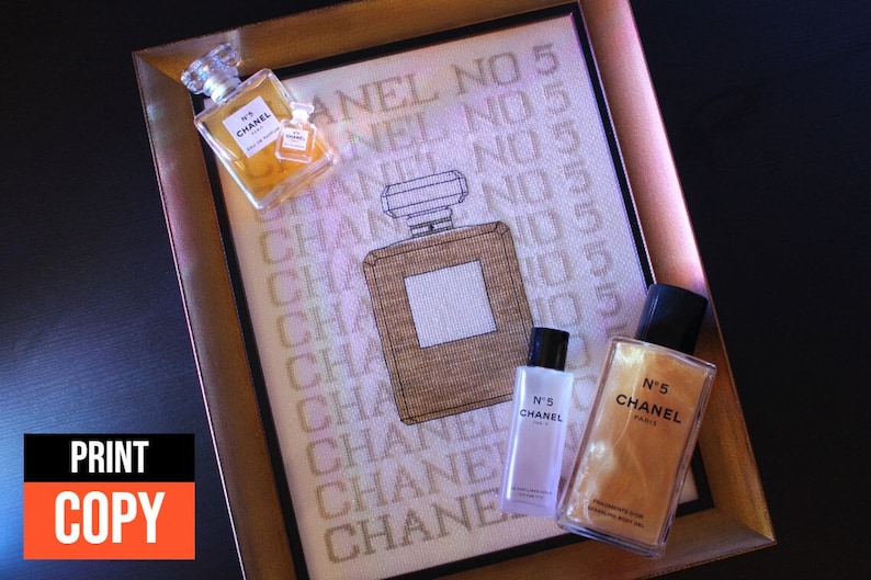 K&ouml;nnte beinhalten: Ein gerahmtes Kreuzstich-Design mit dem Wort "Chanel No. 5", das mehrmals wiederholt wird. Es sind vier Flaschen Chanel No. 5 Parf&uuml;m auf dem Bild zu sehen, zwei davon im Rahmen und zwei au&szlig;erhalb des Rahmens.