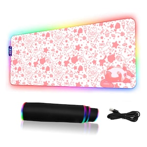 Peut inclure: Un tapis de souris rose et blanc avec un motif répétitif de chats, de cupcakes et de bonbons. Le tapis de souris a un éclairage LED arc-en-ciel autour du bord. Le tapis de souris est enroulé et est livré avec un câble USB.
