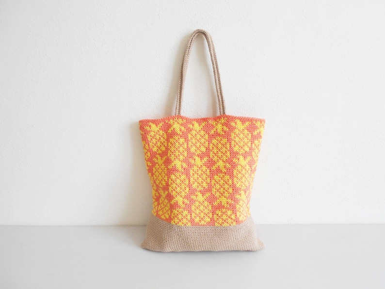 May include: A yellow and orange crocheted tote bag with a brown base. The bag has a geometric pattern.