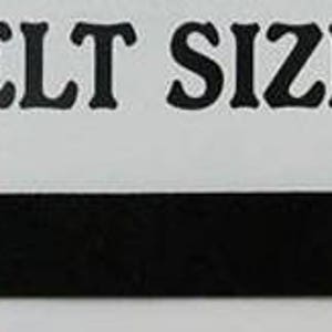 May include: A black leather belt with a silver buckle and five belt holes. The text "BELT SIZE" is printed above the belt. The text "To hole you currently wear" is printed below the belt.